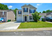 Charming two-story home featuring a well-manicured lawn, attached garage, and traditional design with black shutters at 7311 Fig Ln, Charlotte, NC 28215