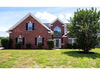 Charming red brick two-story home featuring a manicured lawn and front yard landscaping at 786 Sw Treva Anne Sw Dr, Concord, NC 28027