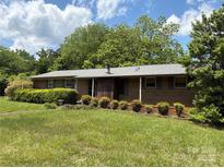 Charming brick home featuring manicured landscaping, a well-maintained lawn, and inviting curb appeal at 947 Ravendale Dr, Charlotte, NC 28216