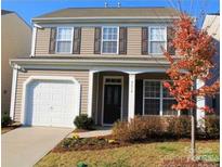 Charming two-story home featuring neutral siding, a single-car garage, and well-maintained landscaping at 9614 Turning Wheel Dr, Charlotte, NC 28214
