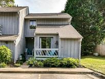 Charming townhome featuring a cozy porch, landscaped garden, and a well-maintained gray wood facade at 100 Willow Run Dr # 26, Gastonia, NC 28056