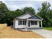 Charming home featuring gray siding, black shutters, and a welcoming front porch at 1024 Short St, Salisbury, NC 28144