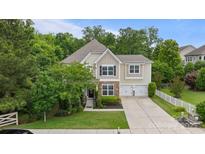 Charming two-story home with stone accents, manicured lawn, two-car garage, and lush landscaping at 1104 Snowbird Ln, Waxhaw, NC 28173