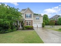 Charming two-story home with stone accents, manicured lawn, and a two-car garage at 1104 Snowbird Ln, Waxhaw, NC 28173