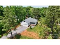 Charming home nestled among mature trees, with a large lawn and gravel driveway at 1406 High Shoals Rd, Lincolnton, NC 28092