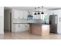 Bright kitchen features white cabinets, stainless steel appliances, black hardware, and a kitchen island at 1537 Spangler Dr, Shelby, NC 28150