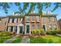 Charming brick townhome featuring black shutters, a welcoming entrance, and beautiful landscaping at 16930 Summers Walk Blvd, Davidson, NC 28036