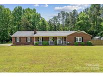 Charming brick home featuring a well-manicured lawn and a welcoming front porch, perfect for enjoying the outdoors at 1753 Elmwood Dr, Rock Hill, SC 29730