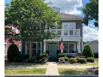 Charming two-story home with a balcony, landscaped yard, and inviting turquoise front door at 2007 Bishops Ct, Cornelius, NC 28031