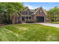 Charming brick home featuring a manicured lawn, two-car garage, and classic architectural details at 2213 Normandin Ct, Charlotte, NC 28216