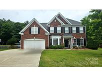 Beautiful two-story brick home with a well-manicured lawn, attached garage, and classic architectural details at 2763 Rivendale Ct, Indian Land, SC 29707