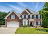 Traditional two-story brick home featuring black shutters, bay window, well-kept lawn, and an attached two-car garage at 2763 Rivendale Ct, Indian Land, SC 29707
