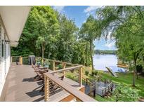 Inviting deck with lake views, wooden railing, steps down to lawn, seating, and grill create an ideal outdoor retreat at 2845 Lakefront Dr, Belmont, NC 28012