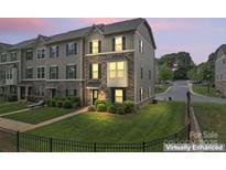 Beautiful townhome with stone accents, well-manicured lawn, and inviting curb appeal at dusk at 3003 Salix Bend Dr, Charlotte, NC 28205