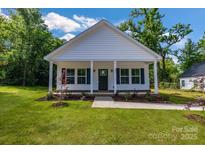 Charming home with a covered front porch, tidy landscaping, and classic white siding at 321 Whitner St, Rock Hill, SC 29732