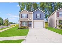 Charming two-story home featuring a manicured lawn and a welcoming two-car garage at 7205 Finnigan Rd, Charlotte, NC 28215
