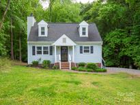 Charming home with light blue siding, dormer windows, and brick stairs leading to a covered front entry at 8905 Vagabond Rd, Mint Hill, NC 28227