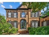 Brick two-story home with black trim, arched windows, and manicured landscaping at 9625 Donna Ve Ln, Charlotte, NC 28277
