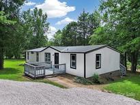Charming single-story home with a cozy front deck and a gravel driveway at 10379 Turnplow Dr, Davidson, NC 28036