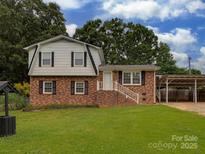 Charming two-story brick home with a well-maintained lawn and attached carport, perfect for suburban living at 1040 Spring Dr, Gastonia, NC 28052