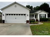 Charming home featuring a two-car garage, brick accents, and a well-manicured lawn at 165 Kimball Rd, China Grove, NC 28023