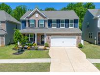 Beautiful two-story home with brick accents, blue siding, well-manicured lawn and a two-car garage at 17228 River Race Dr, Huntersville, NC 28078