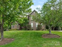 Charming brick home with a lush green lawn and mature trees in a desirable neighborhood at 1814 Therrell Farms Rd, Waxhaw, NC 28173