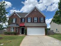 Charming two-story brick home featuring a two-car garage, manicured lawn, and a classic design at 2018 Rockycreek Ln, Monroe, NC 28112