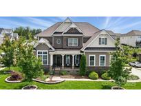 Beautiful two-story home with brick and siding, lush landscaping, and inviting front porch at 220 Forsythia Ln, Tega Cay, SC 29708