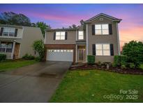 Charming two-story home featuring a well-maintained lawn, two car garage, and manicured landscaping at 2306 Nettleton Ct, Matthews, NC 28105