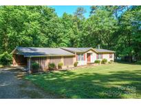 Charming single-story home with a lush green lawn and a carport, perfect for suburban living at 2310 Alexis Lucia Rd, Stanley, NC 28164