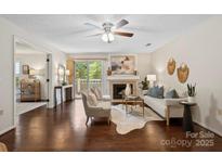 Bright living room with hardwood floors, fireplace, and a sliding glass door to a balcony at 5011 Sharon Rd # Q, Charlotte, NC 28210
