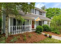 Charming two-story home featuring a welcoming front porch with decorative accents and landscaping at 6512 Porterfield Rd, Charlotte, NC 28226