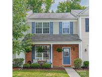 Charming two-story townhome with a cozy brick facade, covered porch, and meticulously maintained landscaping at 6917 Rothchild Dr, Charlotte, NC 28270