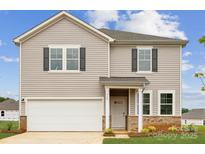 Two-story home showcasing gray siding, black shutters, a two-car garage, and a covered entryway at 710 Olde England Dr, Lincolnton, NC 28092