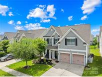 Charming two-story home features a manicured lawn, two-car garage and inviting curb appeal under a bright, cloudy sky at 7316 Hamilton Bridge Rd, Charlotte, NC 28278