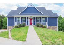 Charming blue two-story home with a red front door and white railings leading to a well-manicured lawn at 7768 Pinecone Ln, Hickory, NC 28602
