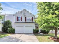 Charming two-story home featuring a two-car garage, red shutters, and landscaped front yard at 10606 Gallowgate Ln, Charlotte, NC 28213