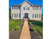 Traditional two-story home featuring manicured lawn and beautiful walkway leading to the front door at 12304 Sandringham Pl, Charlotte, NC 28262
