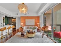Bright living room featuring a modern lighting fixture and access to a cozy balcony space at 1315 East Blvd # 410, Charlotte, NC 28203