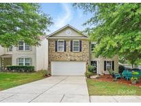Charming two-story home with a well-manicured lawn and attached two-car garage at 1332 Waterlily Ln, Charlotte, NC 28262
