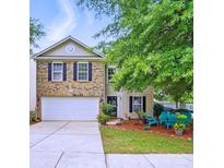 Charming two-story home featuring a brick facade, a two-car garage and a well maintained front yard at 1332 Waterlily Ln, Charlotte, NC 28262