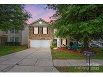 Charming two-story home with a well-maintained lawn, inviting front porch area, and two car garage at 1332 Waterlily Ln, Charlotte, NC 28262