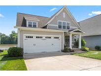 Charming two-story home with a two-car garage, well-manicured lawn, and lake view at 136 Preston Rd, Mooresville, NC 28117