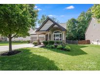 Charming home with lush lawn, tasteful landscaping, and welcoming covered porch, perfect for relaxing at 14512 Brotherly Ln, Charlotte, NC 28278