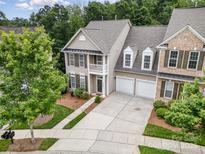 Inviting two-story townhome boasting a two-car garage, second-story porch, and mature landscaping at 14822 Rocky Top Dr, Huntersville, NC 28078