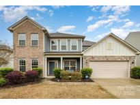 Charming two-story home featuring a brick and siding exterior, landscaped front yard, and attached two-car garage at 2014 Drawbridge Dr, Fort Mill, SC 29707