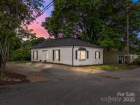 Charming single-story home featuring a brick facade, black shutters, and a well-maintained yard at 207 Eden St, Davidson, NC 28036