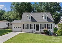 Charming home with grey siding, black shutters, well-maintained lawn, and beautiful landscaping at 20840 Sierra Vista Dr, Cornelius, NC 28031