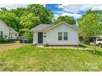 Charming single-story home with white siding, a well-manicured lawn, and lush green trees at 211 E Mcneely Ave, Mooresville, NC 28115